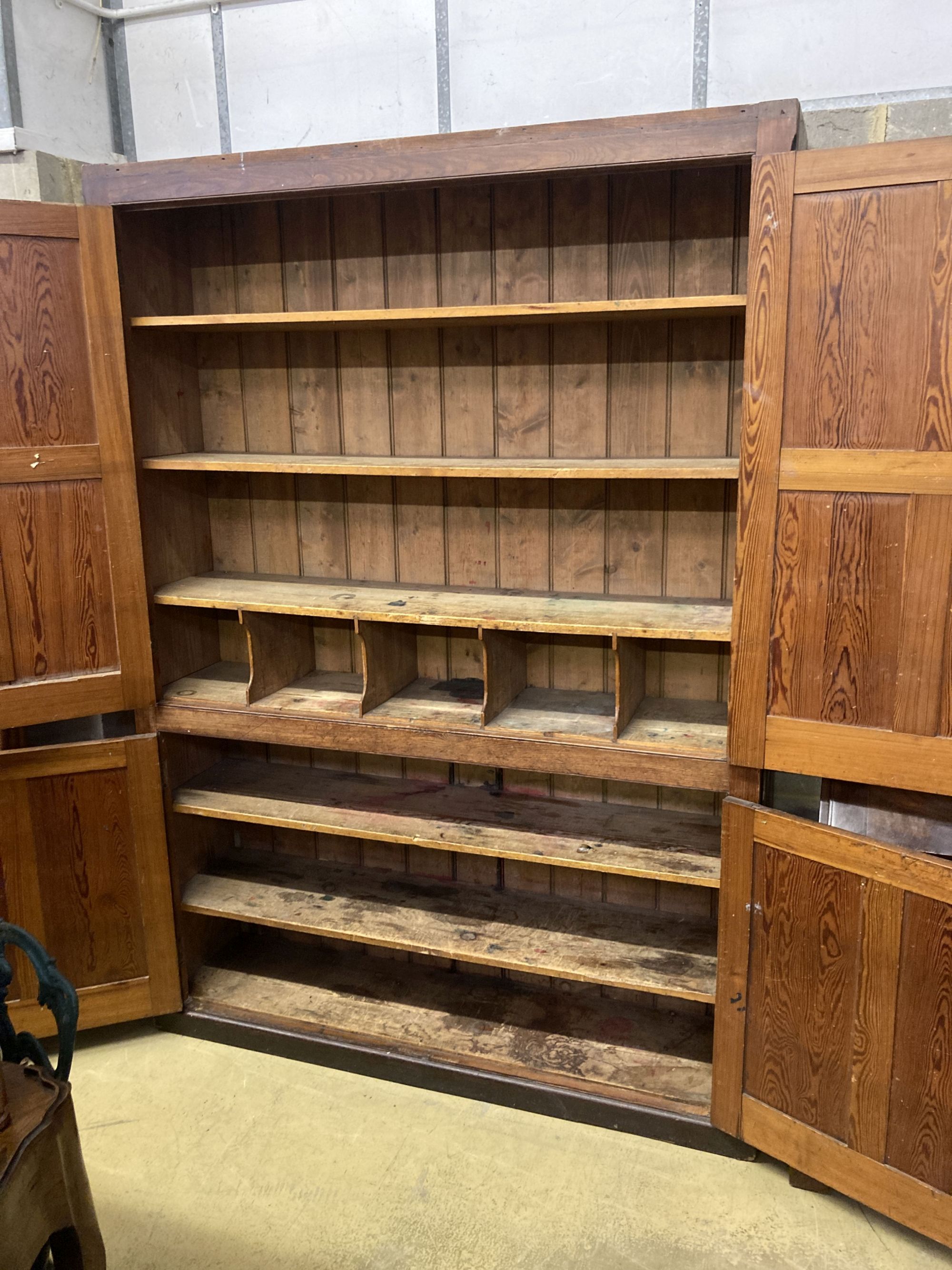 A Victorian panelled pitch pine four door cabinet, upper section marked in gilt, Newnham Girls College Cambridge music sheets and book